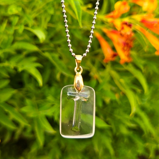 Letter T initial necklace made from clear recycled whiskey bottle glass with original raised lettering