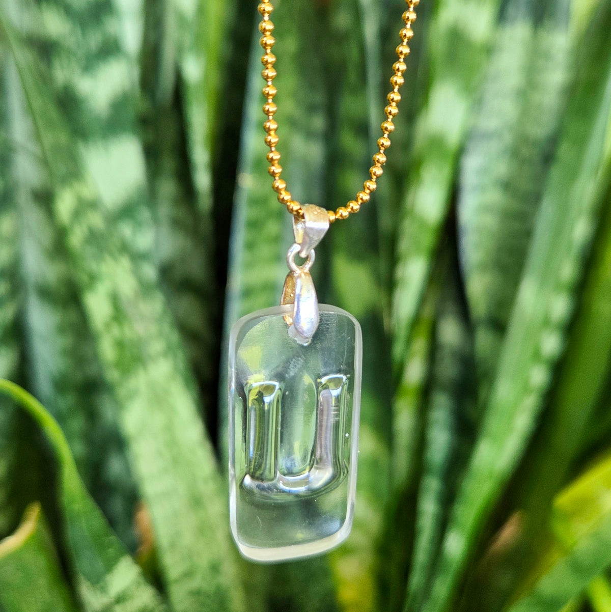 Letter U initial necklace made from clear recycled bourbon bottle glass with original raised lettering